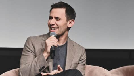 Benj Pasek smiling while talking into a mic.