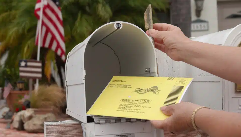 Close up of an American mailbox with flags in the background.