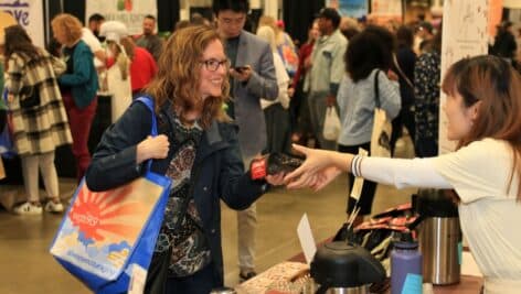 A happy customer getting Vietnamese Coffee Beans at festival.