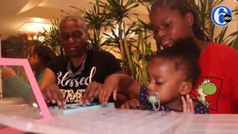 DebiAnn Henderson Scott (left) works with a mom and her child on a jewelry project at the "Never Accepting Negativity" resource center in Willow Grove.