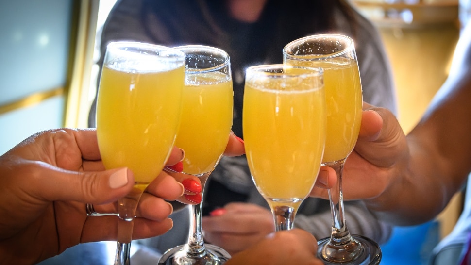 four people hoist a memosa toast.
