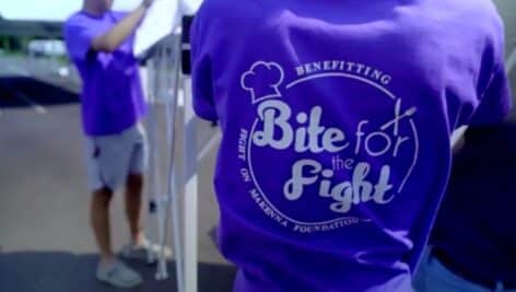 Women wearing Bite for the Fight shirt at event.