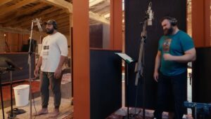 Jason Kelce and Jordan Malaita in a recording booth singing for their Christmas album