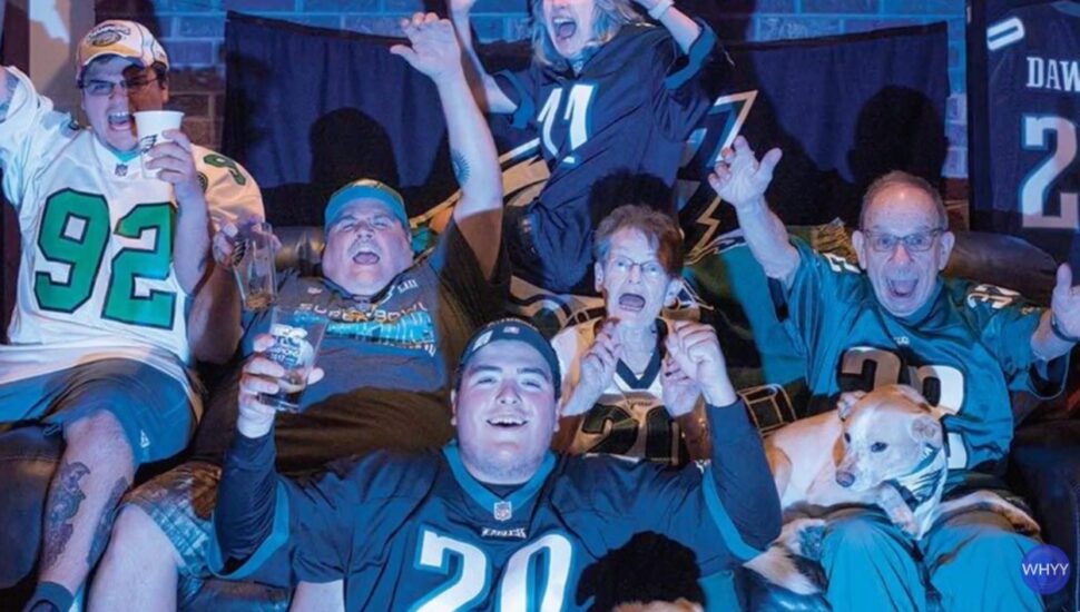 Philadelphia Eagles fans cheering around a TV.