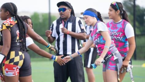 Girls flag football -- lined up with referee.