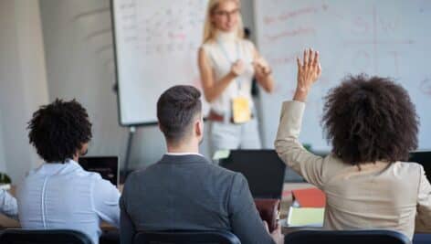 A group of professionals attending a small business seminar, listening to instructor.