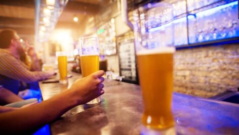 A pint of beer on a bar top.