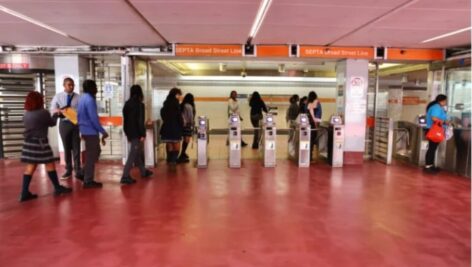 Commuters walk through the turnstiles at SEPTA.