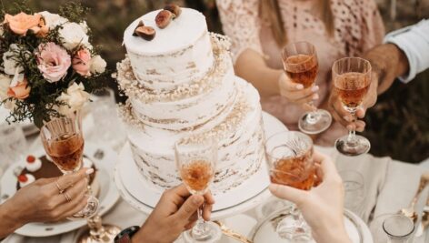 A champagne toast over a wedding cake.