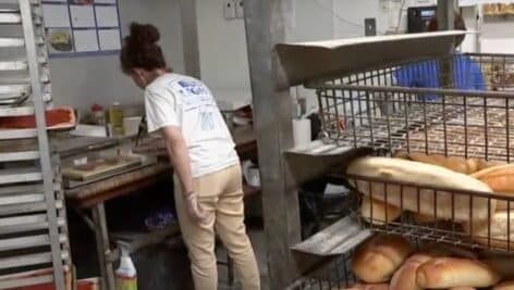 Tina Gambone preparing a tomatop pie at Conshohocken Italian Bakery.