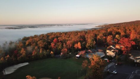 An aerial view of Refreshing Mountain in Lancaster County. The landscape is filled with colorful fall trees and the woodland expanse.