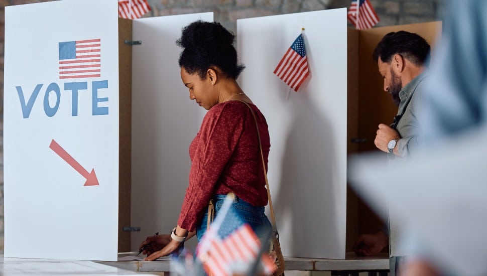 African American woman at voting booth during US elections.