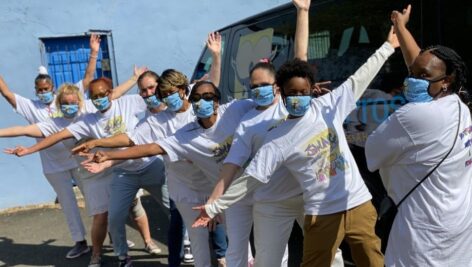 A group of formerly incarcerated women posing with open arms.