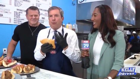 Bob Kelly of Fox 29s Kelly Drives, samples The Crossover sandwich with PhastBreak Cheesesteaks owner Bill McKee and his wife, Ocean Sapphire.