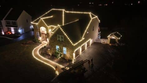 Aerial view of a residential property lit by Four Seasons Property Services.