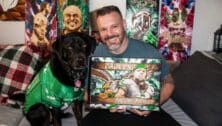 Jon Metz posing with his artwork and his dog.