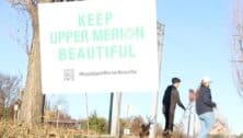 Michael Bugler cleaning up Upper Merion behind a 'Keep Upper Merion Beautiful' sign