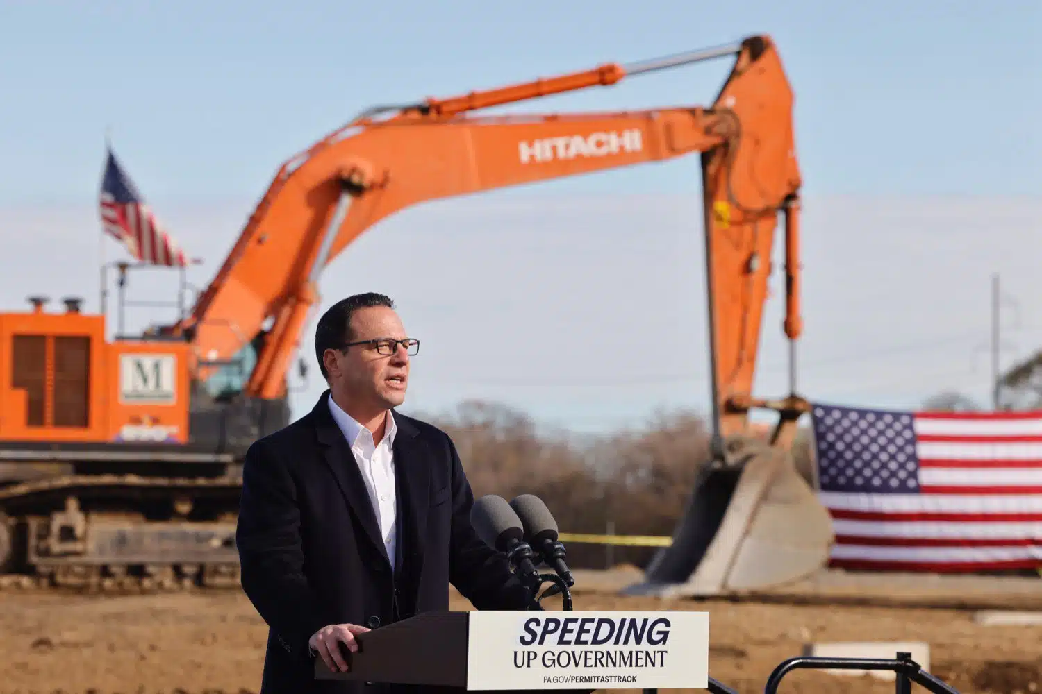 Governor Josh Shapiro addresses a crowd in front of a developing site.
