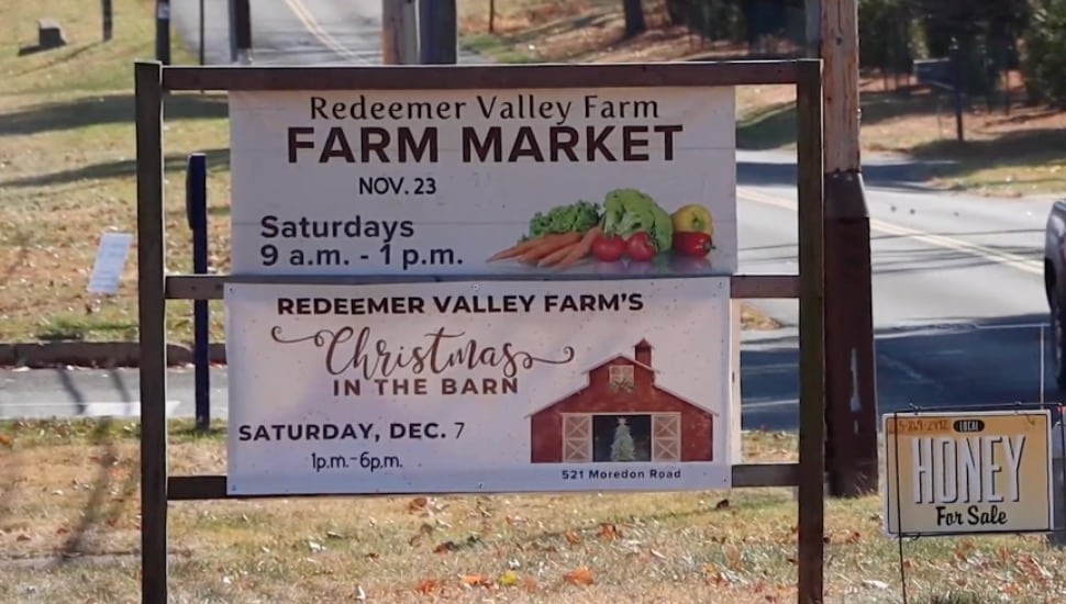 A roadside sign advertising Redeemer Valley Farm Farmer's Market