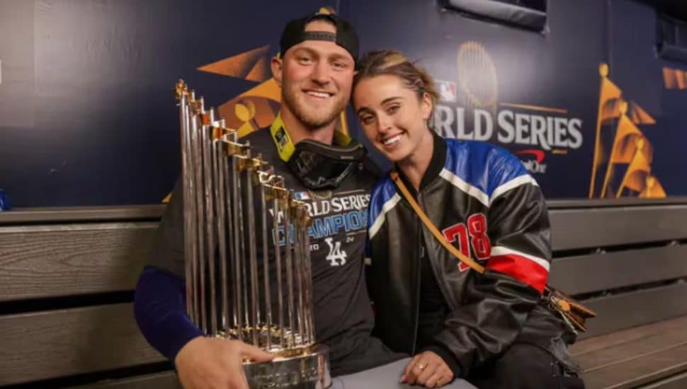 Erin Matson sitting with boyfriend Ben Casparius with World Series trophy.