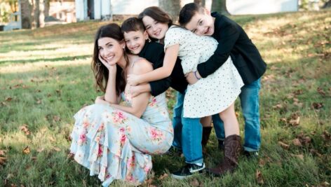 Ann Marks with three children posing on a lawn.