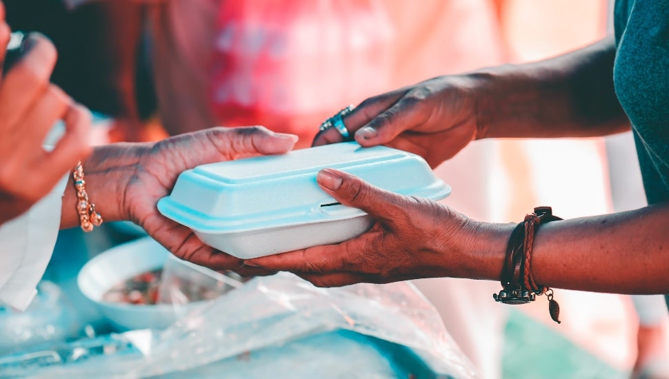 Hands exchanging food at a food drive.
