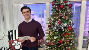 John Battagliese in front of a Christmas tree.