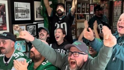 Eagles fans cheering as they watch the game at Lombard House.