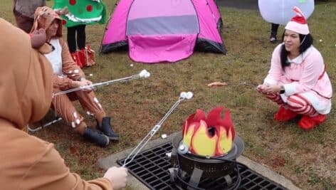 Principal Sar Rattigan dressed as elf Pixie grilling hot dogs with her reindeer.