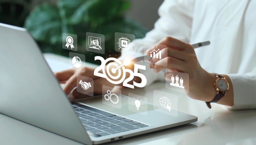 Businessperson plans for 2025 on laptop computer.