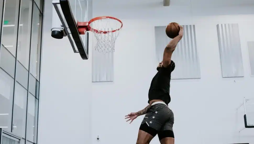 Eric Dixon is in mid-air dunking a basketball.