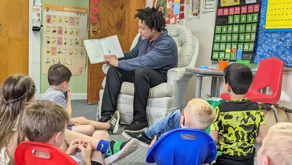 Student-teacher reads to children.