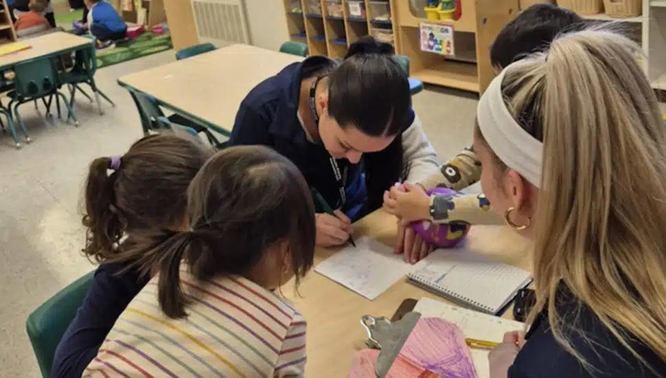 Graduate student works with children.