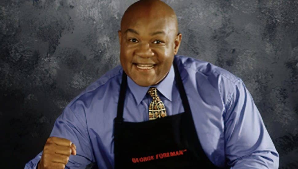 George Foreman wearing apron.