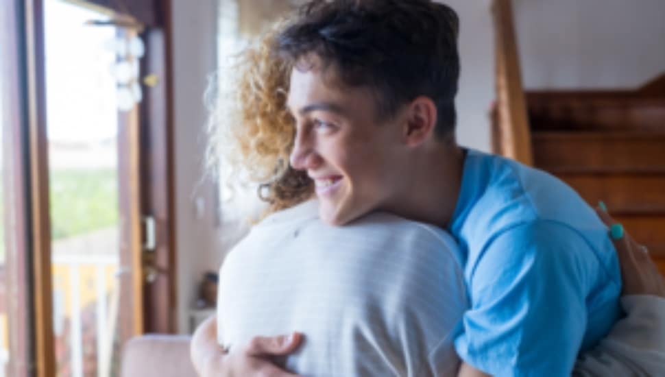 A young man hugs a woman