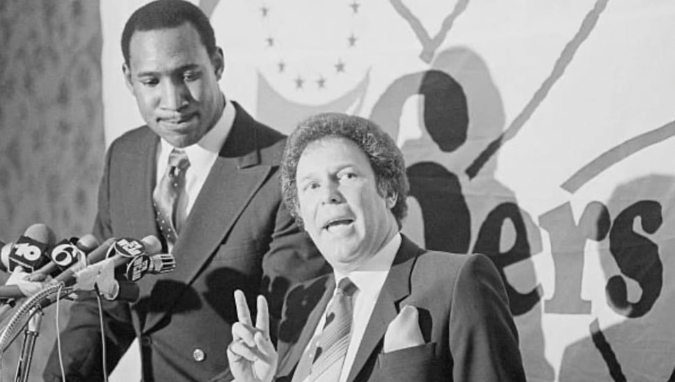 Black and white photo of Harold Katz offering the sign of peace.