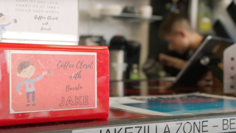 A napkin holder displaying 'Jake's Baristas' on the counter in the coffee shop.
