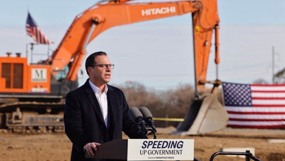 Politician addresses media at a construction site.