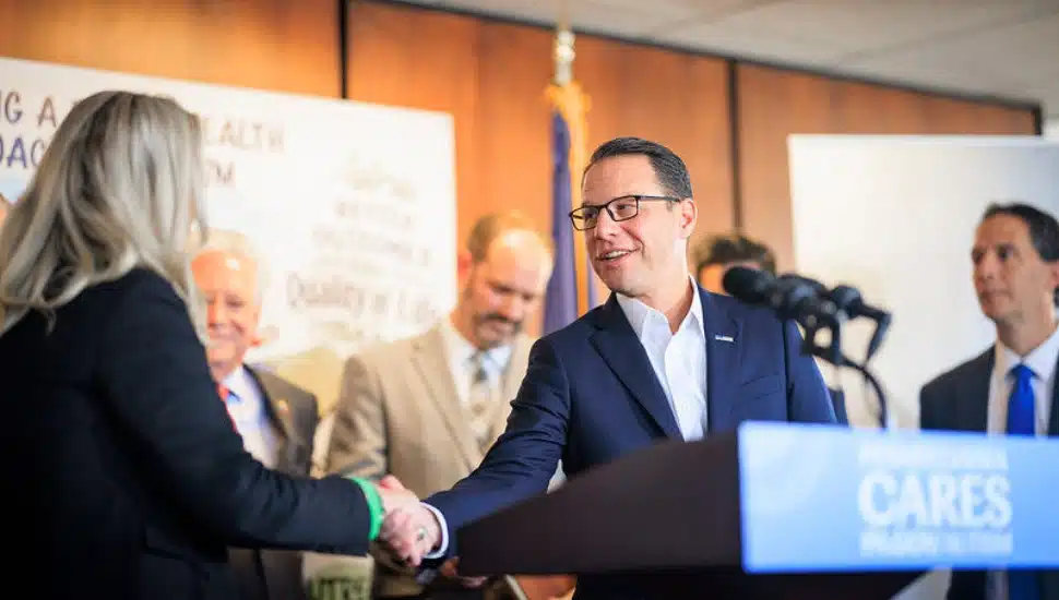 Josh Shapiro shaking hands from a podium.