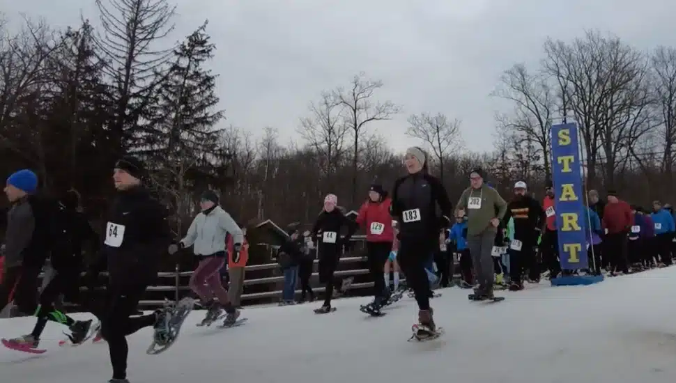 Competitors running off the starting line in the snowshoe 5k.