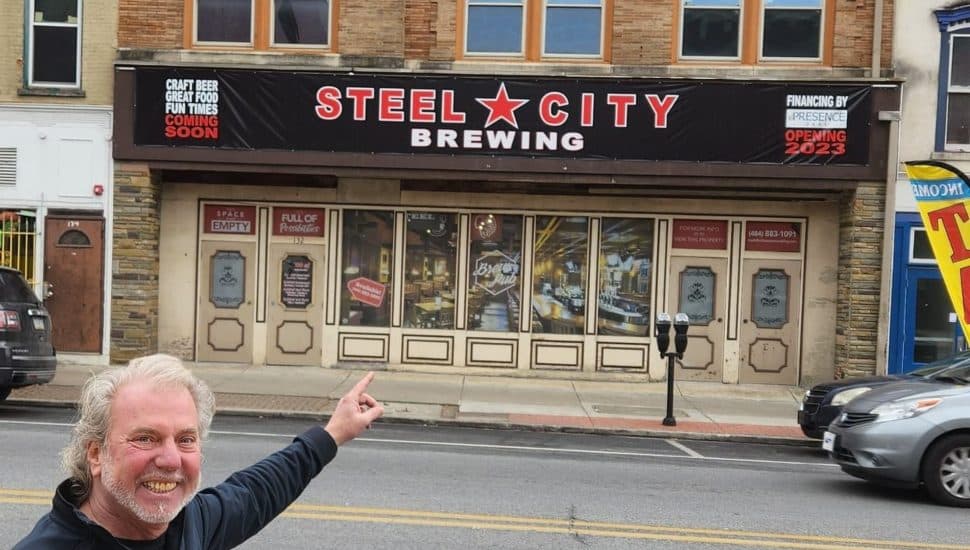 Man points at Steel City Brewing.