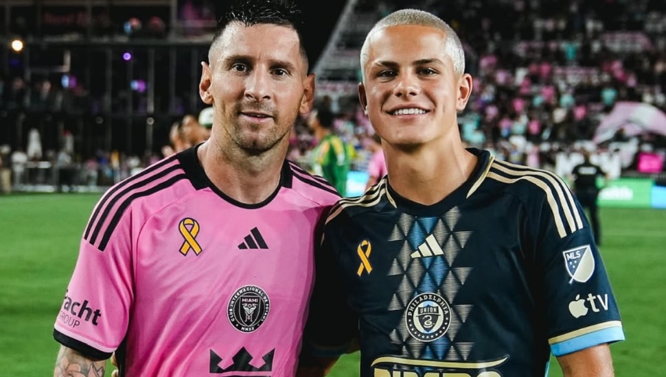 Cavan Sullivan poses with Lionel Messi on the pitch.