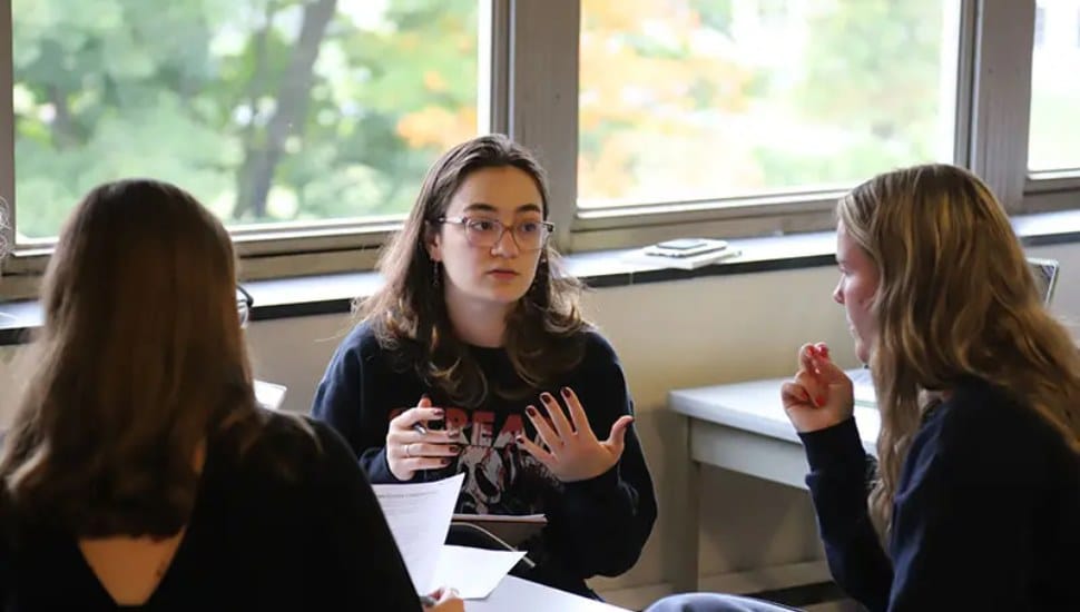 Immaculata University crisis management students sit at a table and discuss ideas.