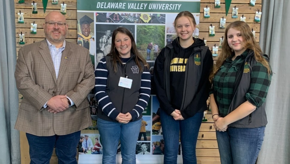 Agricultural students and professor pose for picture at a farm show.