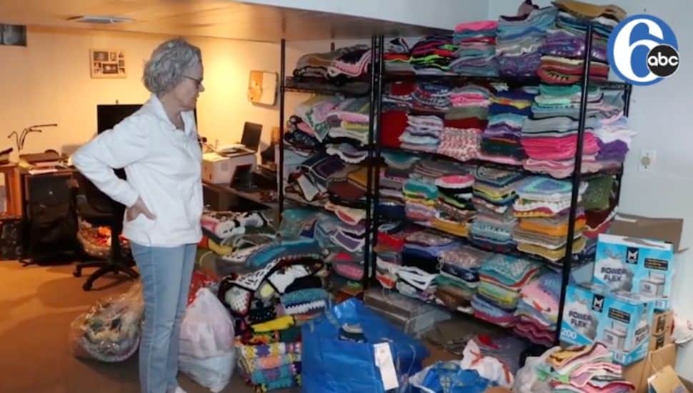 Woman looking at crocheted blankets.