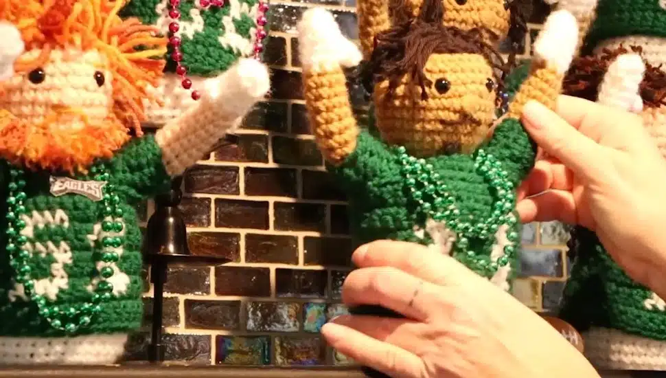 Crocheted Eagles dolls sit on a mantle.