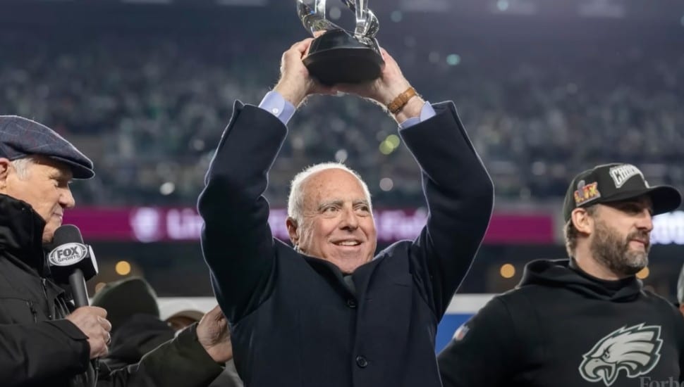 Jeffrey Lurie hoisting up a trophy.
