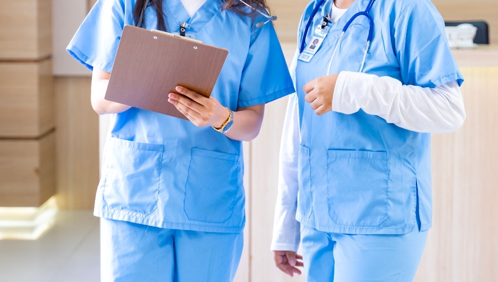 Nurses examining a clipboard.