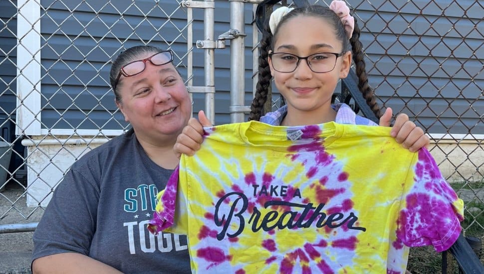 Recipients holding up a Take a Breather shirt.