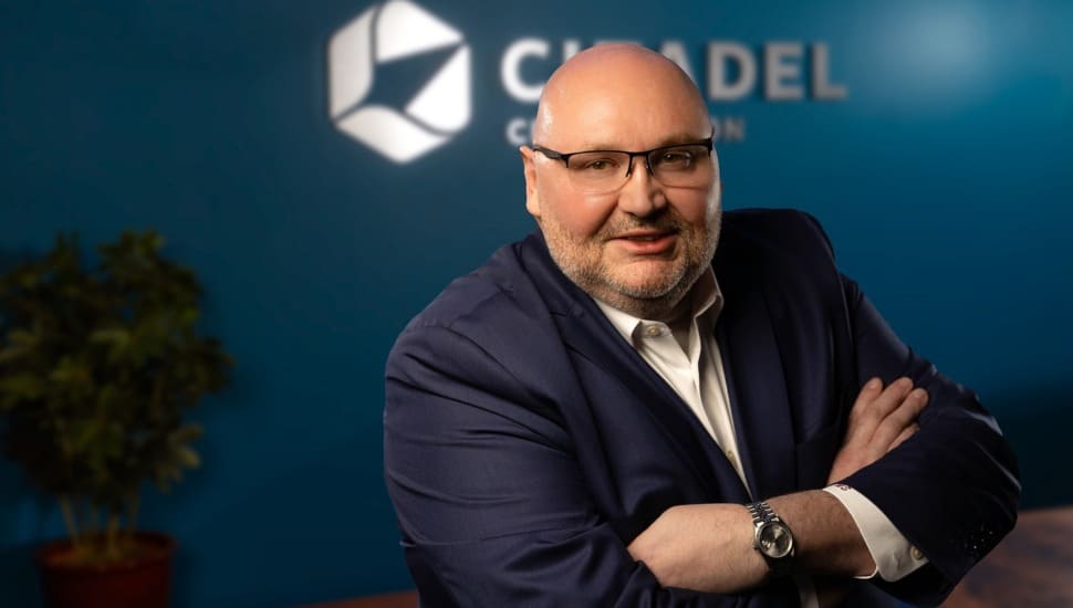 Headshot of banking executive with arms folded.